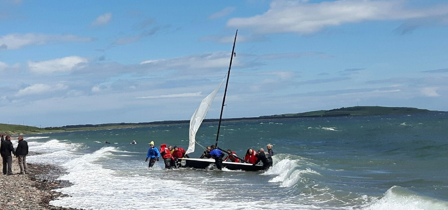 Fans help the boat up the beach